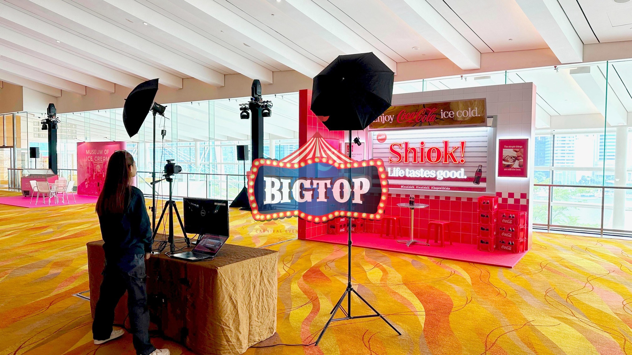 Branded photobooth with red Coca-Cola backdrop and two studio lights